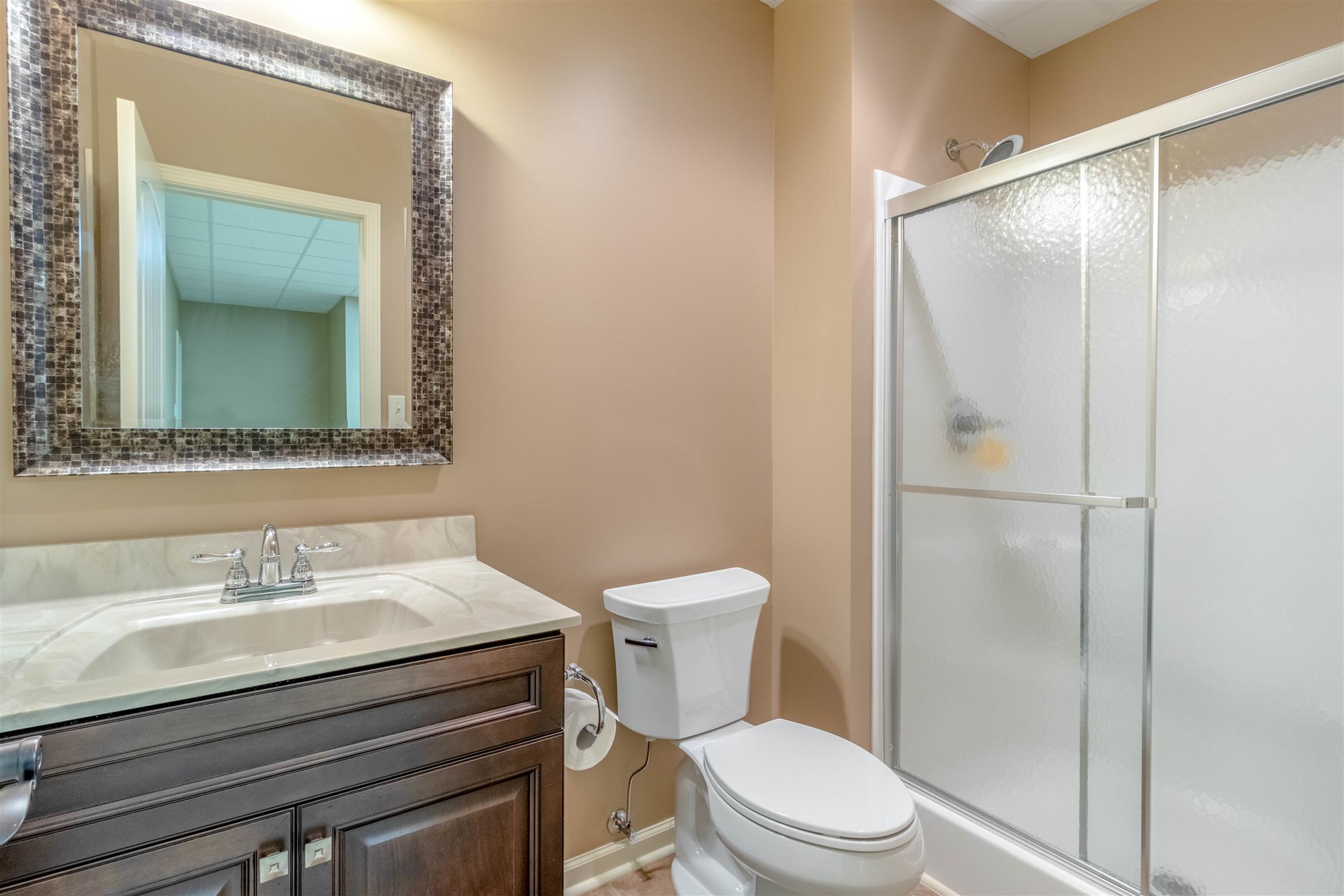 2687 Gunn Road Adams, TN 37010 - Photo 23 of 30 a bathroom with a sink a toilet a mirror and shower