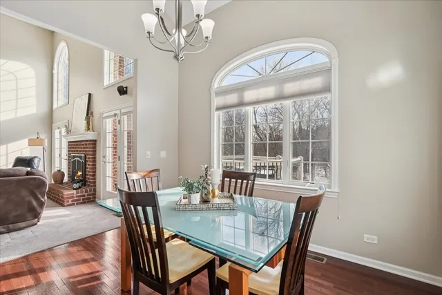 a view of a dining room with furniture a chandelier and wooden floor