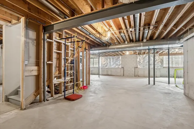 a view of an empty room with wooden floor and windows