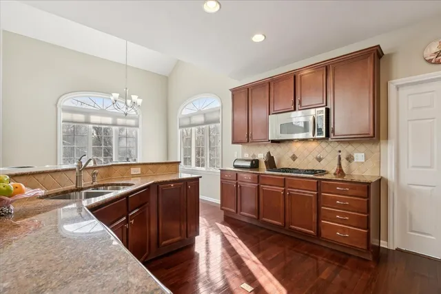 a kitchen with stainless steel appliances granite countertop a sink stove and cabinets