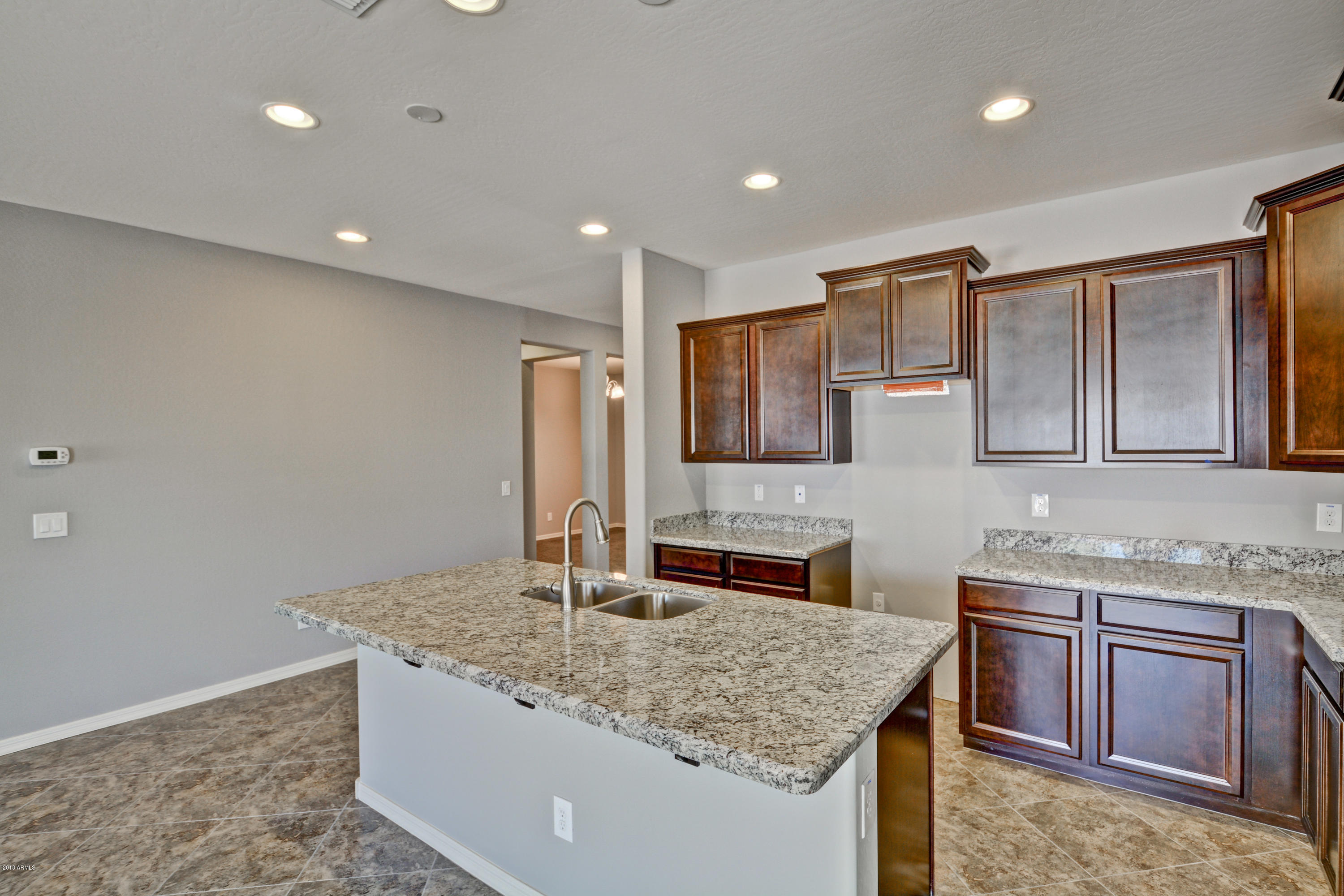 16746 West Rowel Road Surprise, AZ 85387 - Photo 18 of 35 a kitchen with stainless steel appliances granite countertop a sink and a refrigerator
