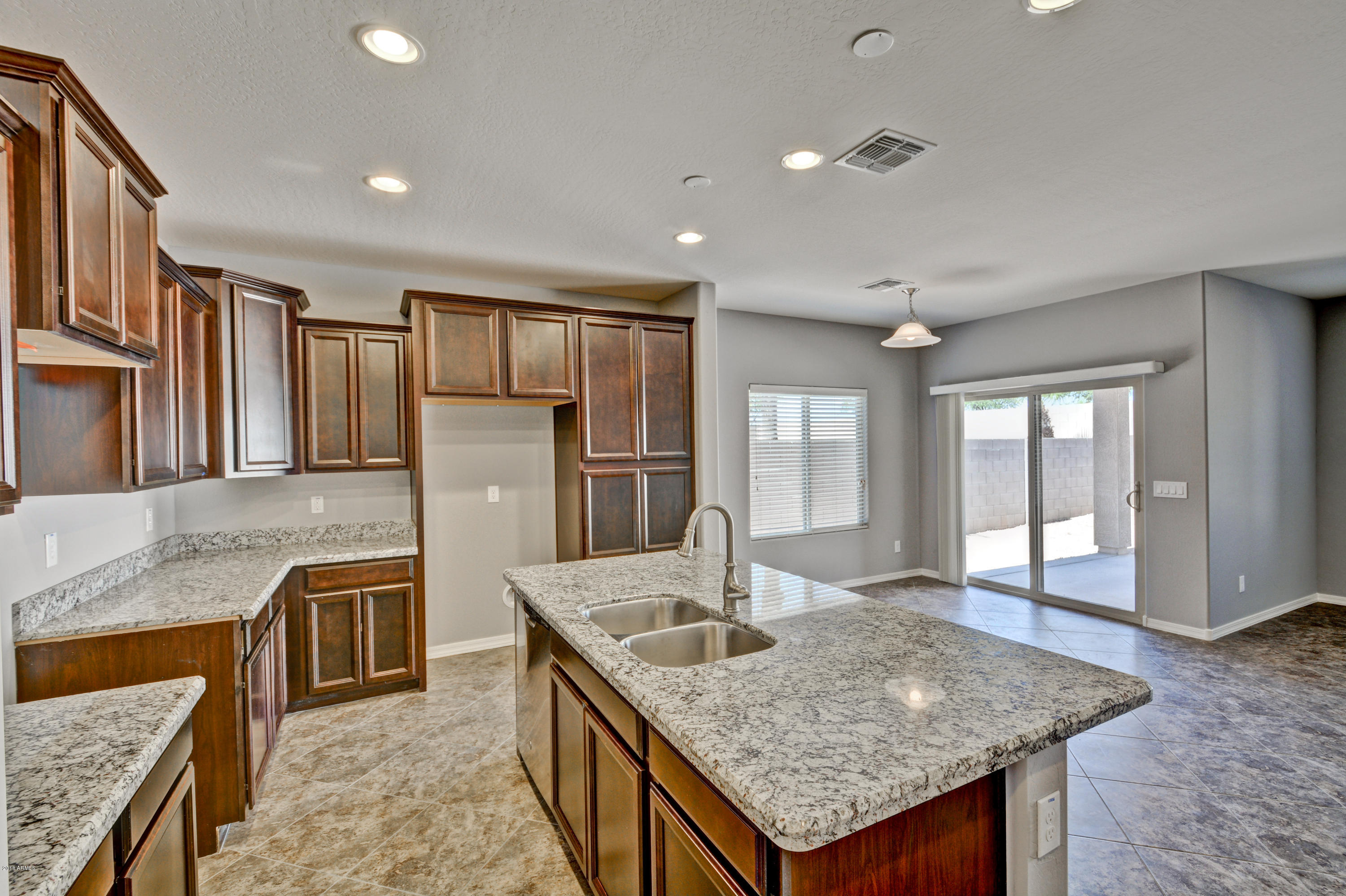 16746 West Rowel Road Surprise, AZ 85387 - Photo 19 of 35 a kitchen with stainless steel appliances granite countertop a sink a stove and a refrigerator