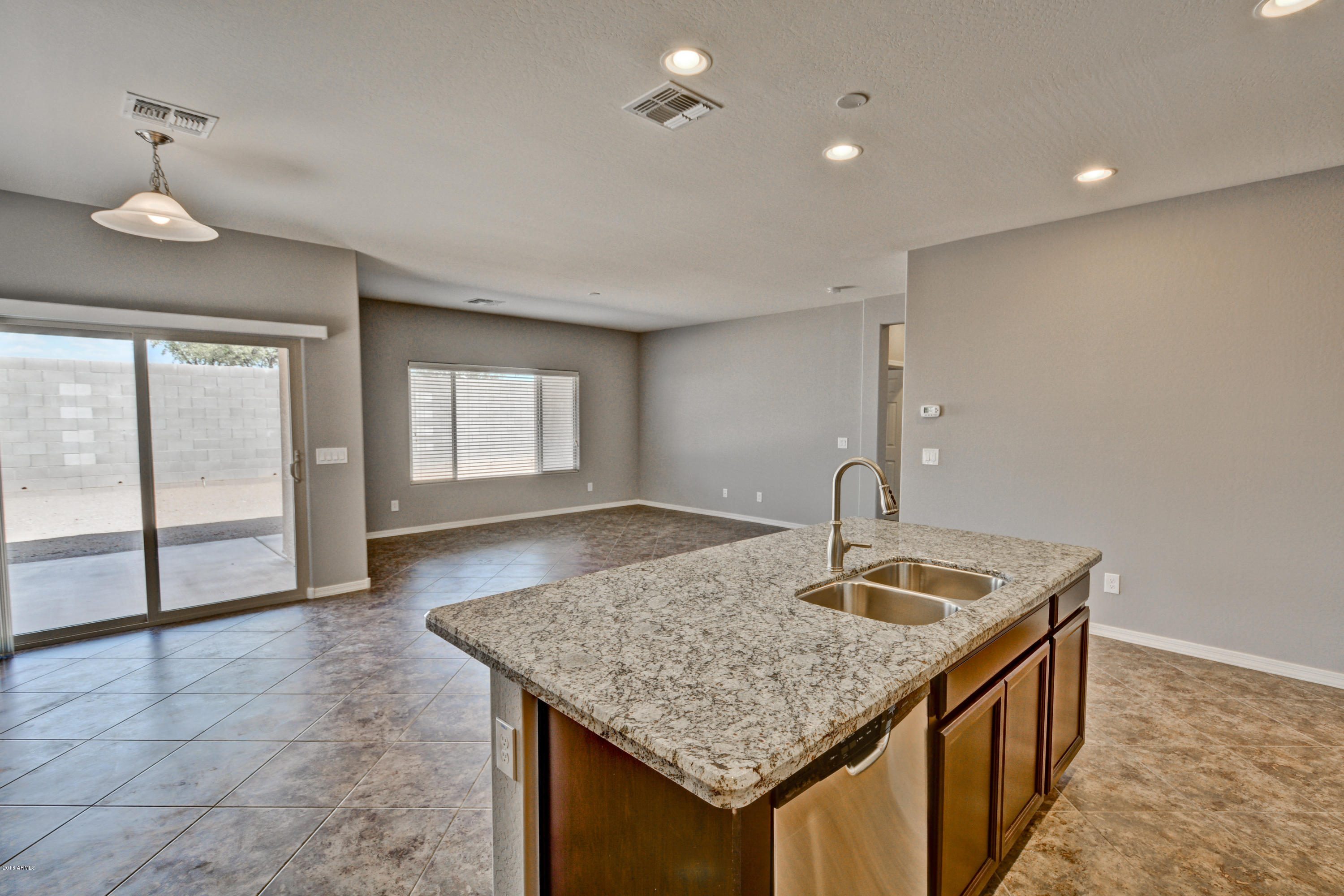 16746 West Rowel Road Surprise, AZ 85387 - Photo 20 of 35 a kitchen with stainless steel appliances granite countertop a sink a refrigerator and a granite counter tops