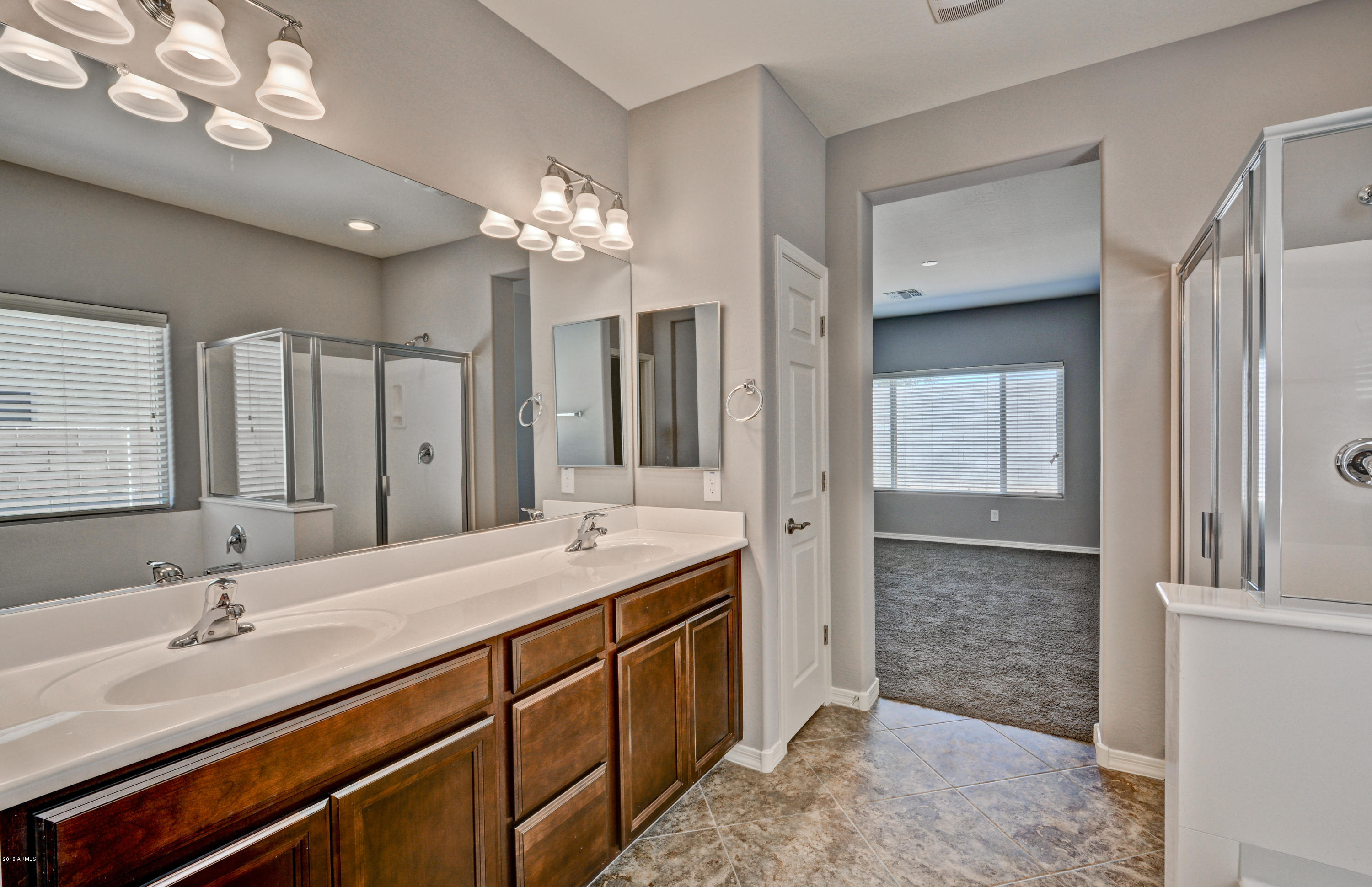 16746 West Rowel Road Surprise, AZ 85387 - Photo 29 of 35 a spacious bathroom with a double vanity sink a mirror and a shower
