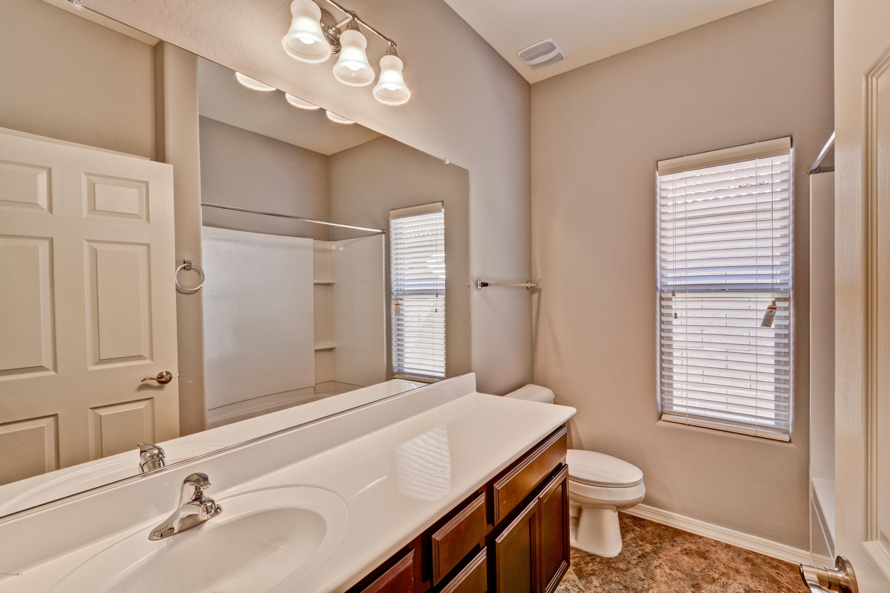 16746 West Rowel Road Surprise, AZ 85387 - Photo 6 of 35 a bathroom with a sink a toilet and a mirror