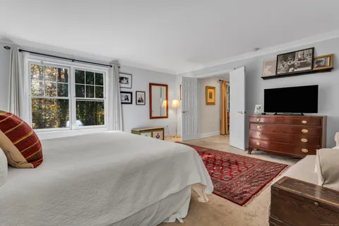 a spacious bedroom with a bed and a flat screen tv