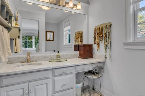 a en suite bathroom with a granite countertop sink and a mirror