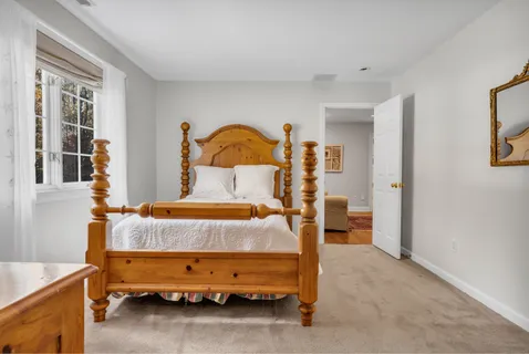 a bed sitting in a room next to a window