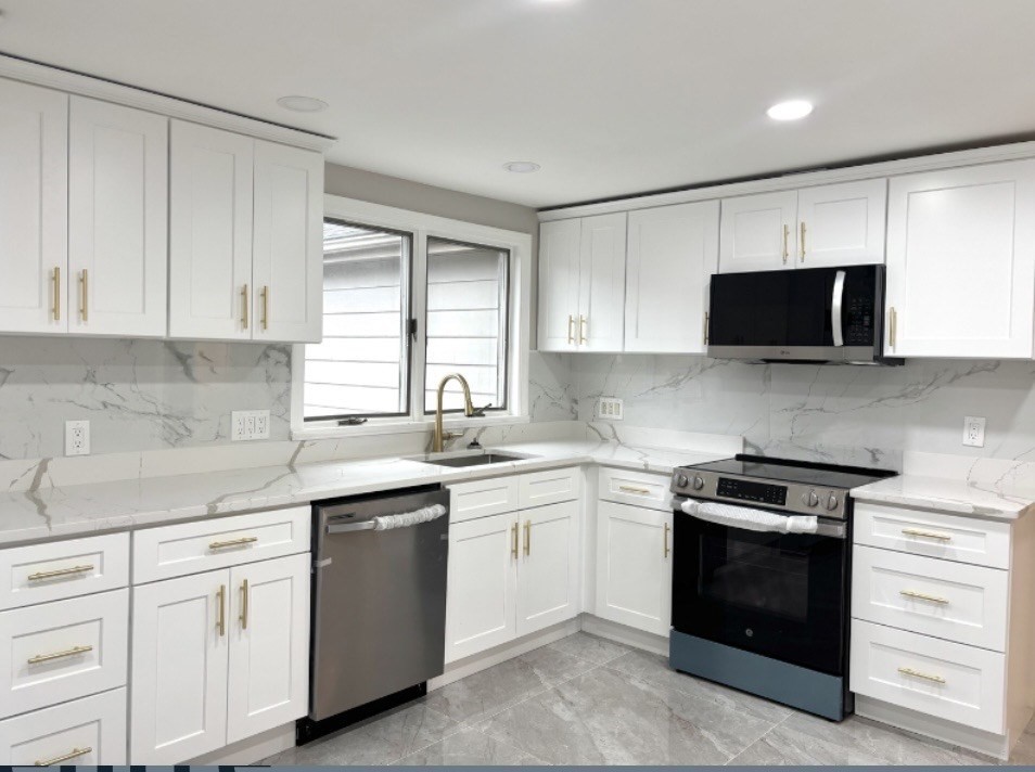338 Langley Road Newton, MA 02459 - Photo 3 of 18 a kitchen with white cabinets and black appliances