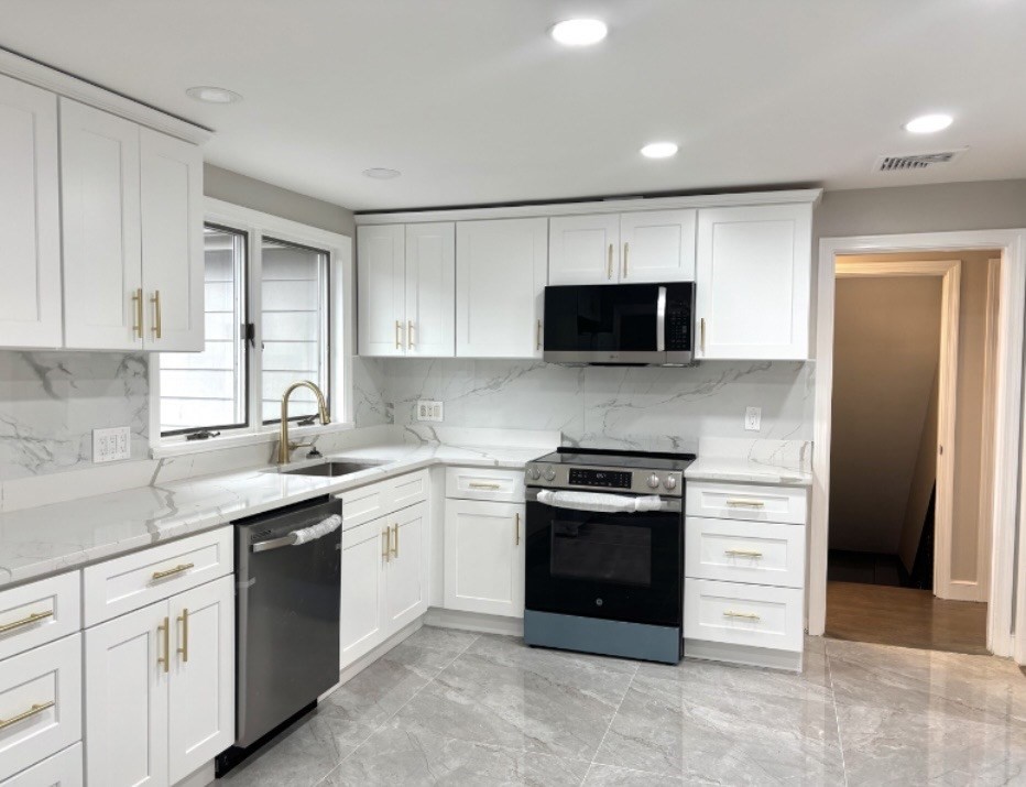 338 Langley Road Newton, MA 02459 - Photo 4 of 18 a kitchen with stainless steel appliances granite countertop a stove a sink and a microwave