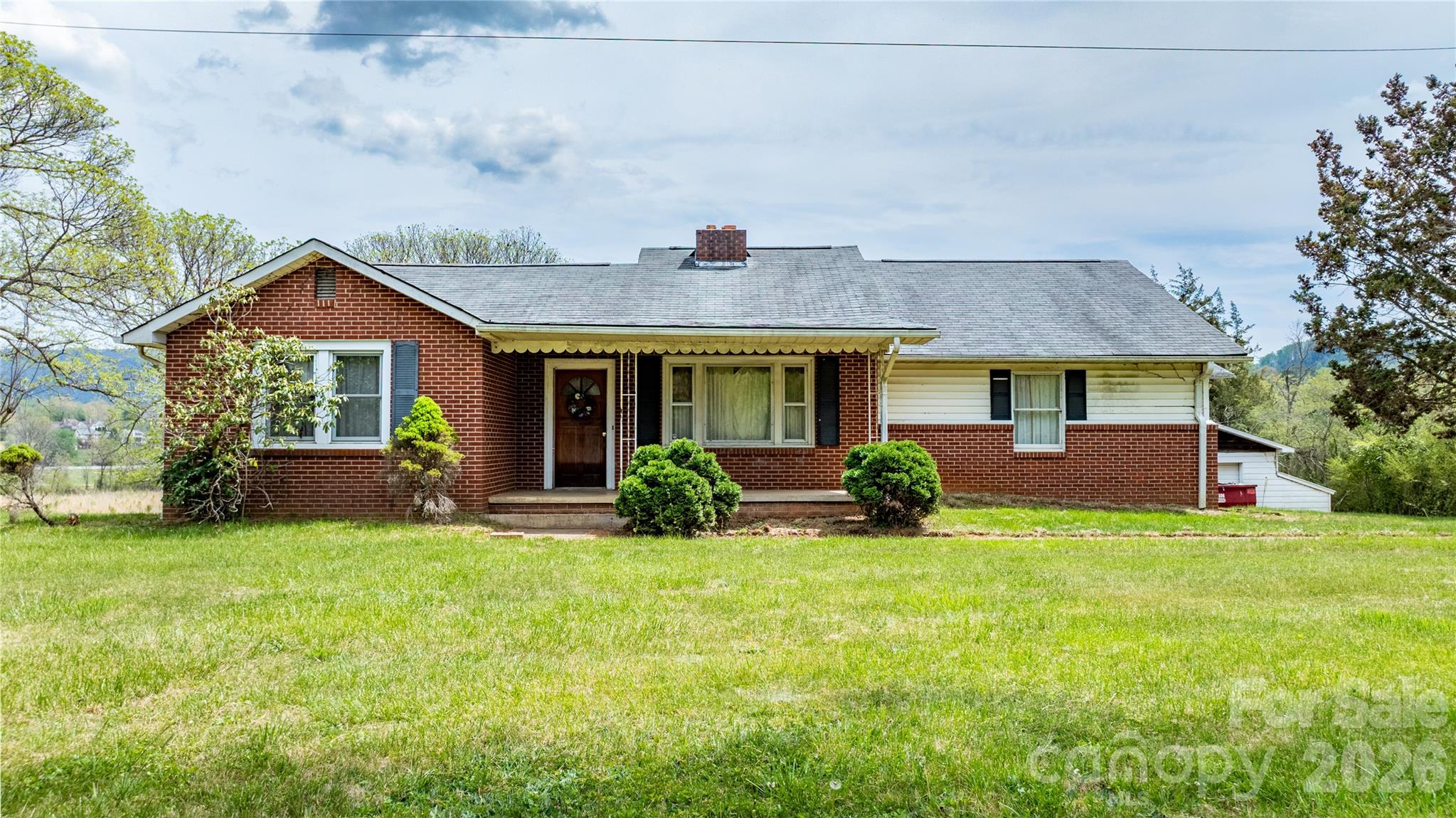 a front view of a house with yard and green space
