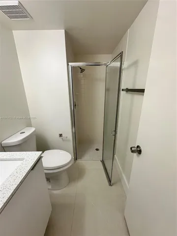 a white toilet sitting next to a shower