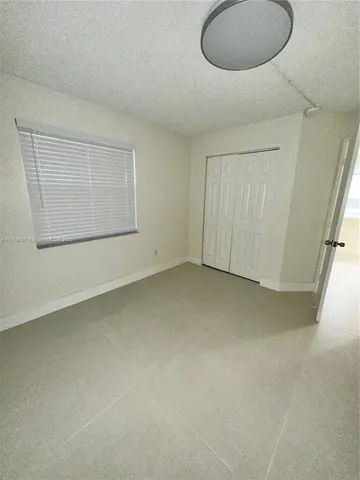 an empty room with a cabinet and a mirror