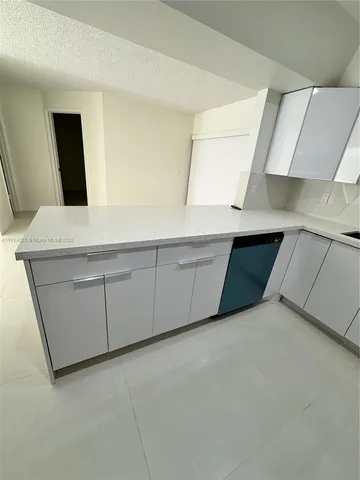 a view of an empty room with cabinet and window