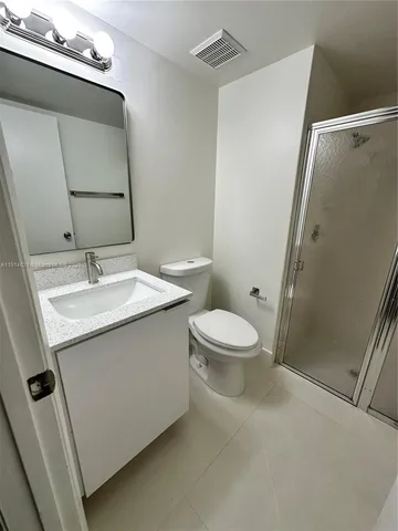 a bathroom with a sink mirror vanity and toilet