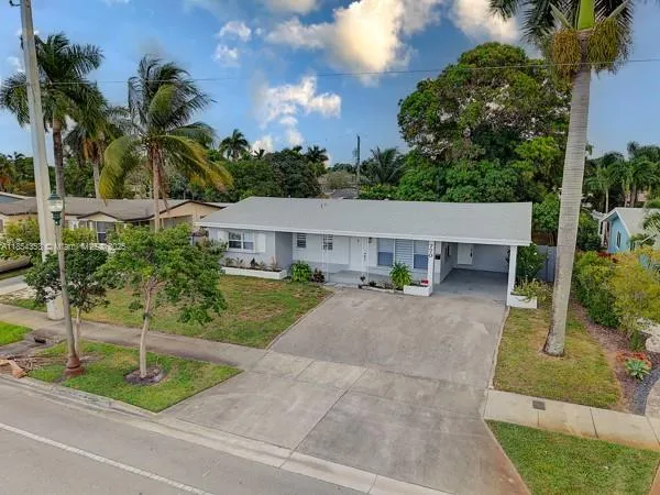 a view of a house with a yard and potted plants
