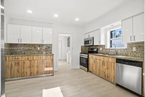 a kitchen with granite countertop stainless steel appliances and white cabinets