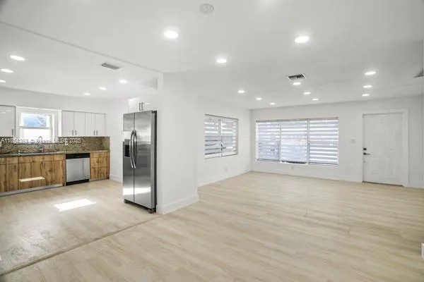 a view of kitchen with refrigerator and window