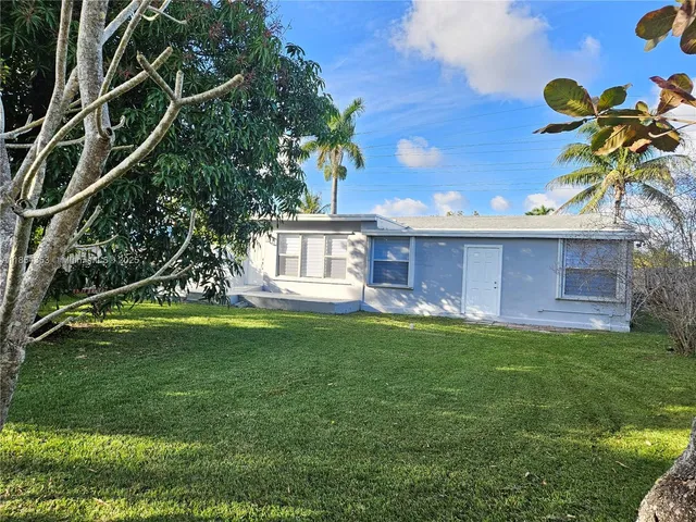 a view of a house with a backyard