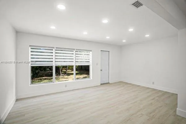 an empty room with a fireplace and wooden floor