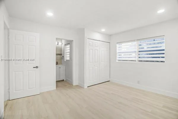 an empty room with windows and closet