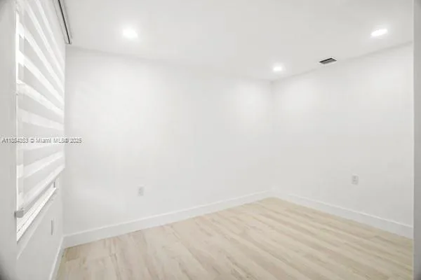 a view of a room with wooden floor and window