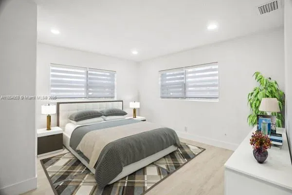 a bedroom with a bed and a potted plant