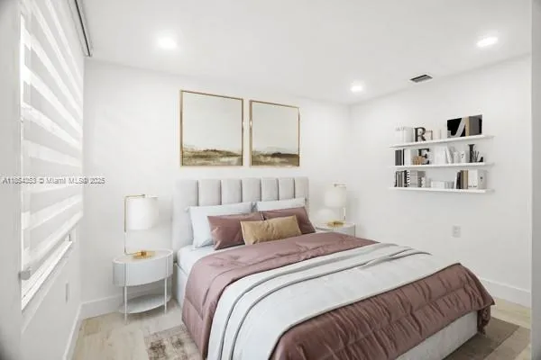 a bedroom with a large bed and a window