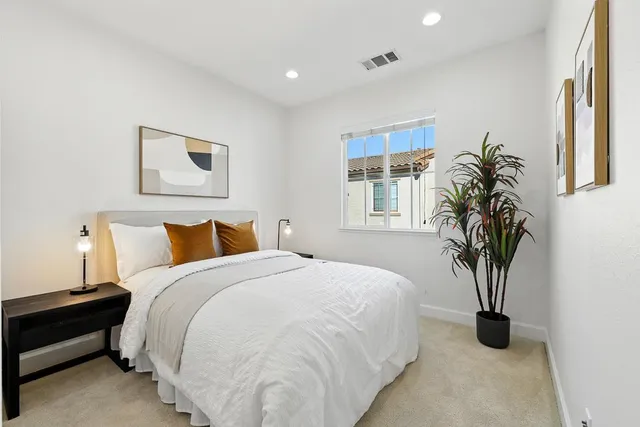 a bedroom with bed and a potted plant