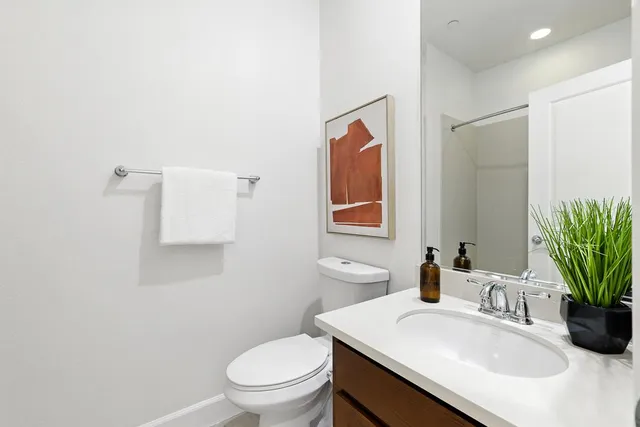 a bathroom with a sink a toilet and mirror