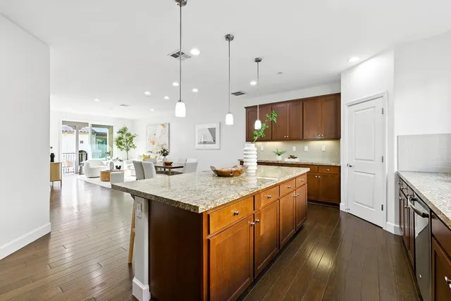 a kitchen with counter top space sink stove and wooden floor