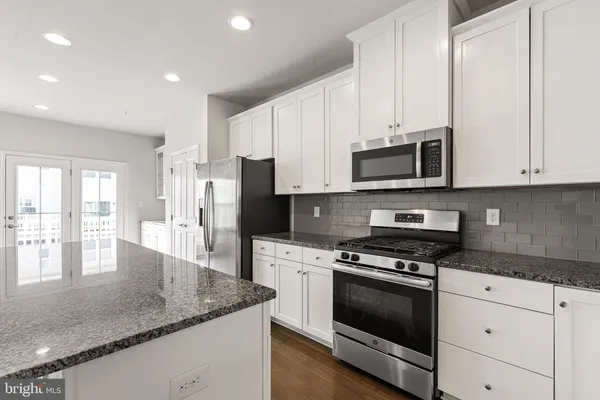 a kitchen with appliances a sink and cabinets
