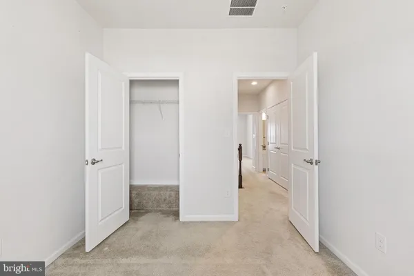 an empty room with closet and a bathroom