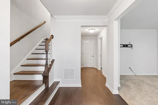 a view of a hallway with wooden floor and entryway