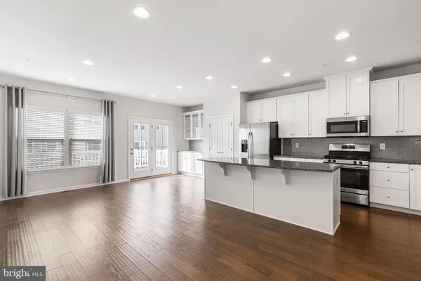 a kitchen with stainless steel appliances a refrigerator and wooden floor