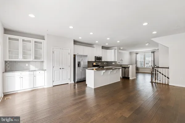 a kitchen with a refrigerator and white cabinets