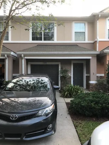 a view of a house with a yard and potted plants