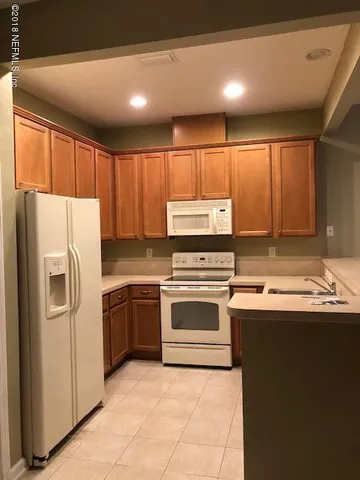 a kitchen with stainless steel appliances granite countertop a refrigerator sink and stove