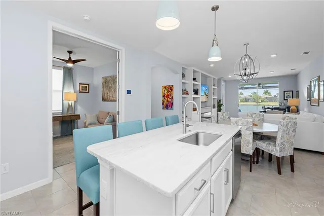 a kitchen with stainless steel appliances a refrigerator a stove a sink a dining table and chairs