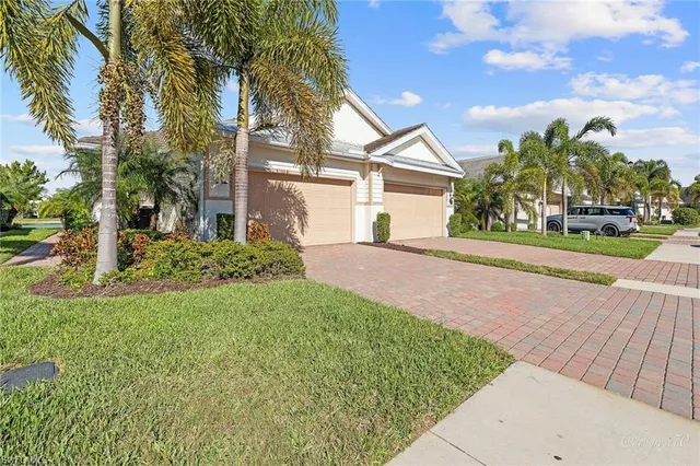 a front view of a house with a yard and potted plants
