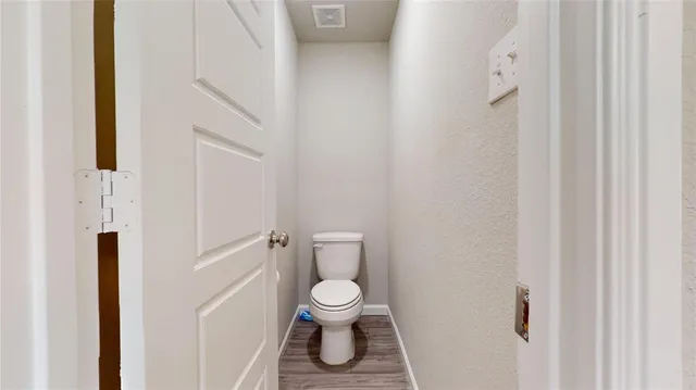 a white toilet sitting next to a white walls