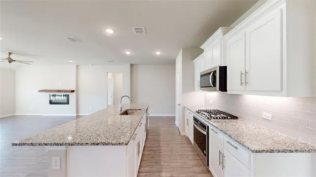 a kitchen with stainless steel appliances granite countertop a sink stove and cabinets