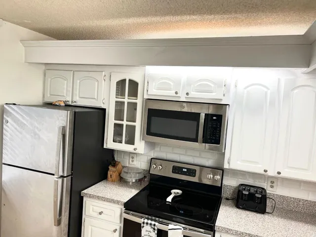 a kitchen with stainless steel appliances a stove microwave and refrigerator
