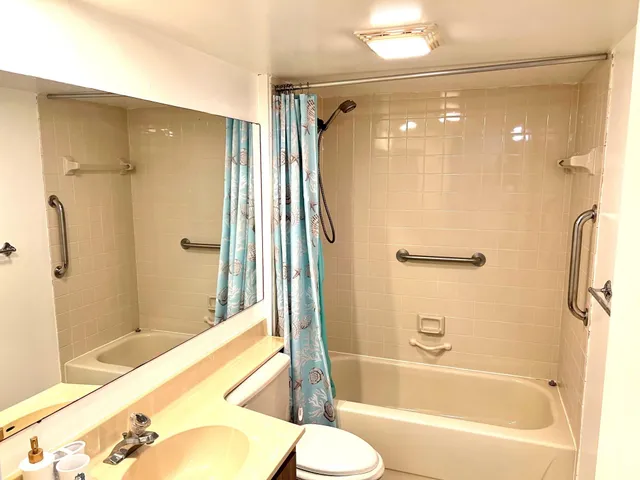 a bathroom with a bathtub shower and a sink