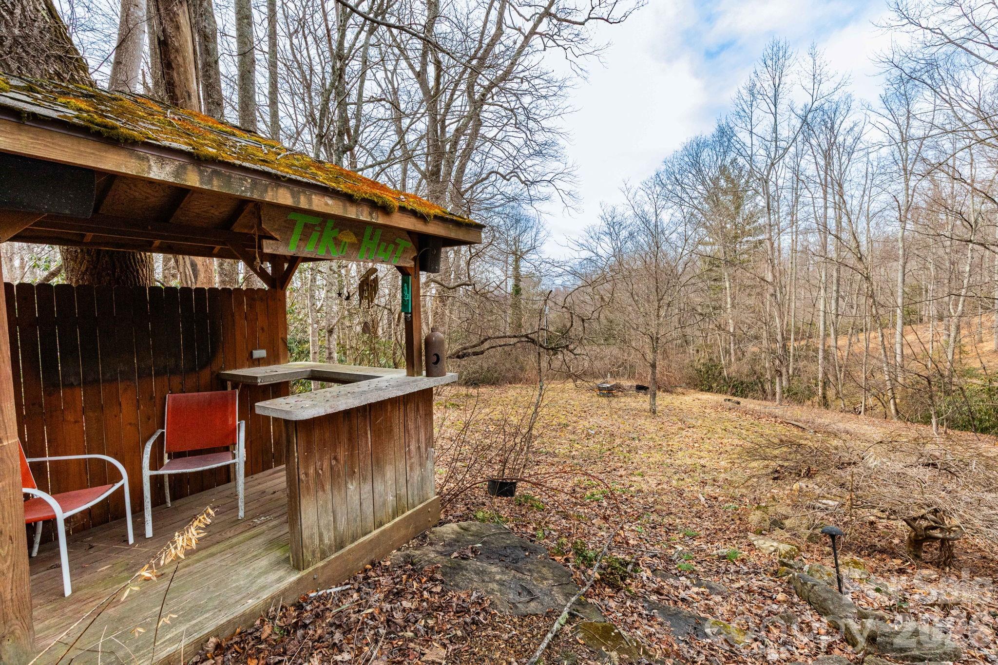 341 Sugar Hollow Road Fairview, NC 28730 - Photo 18 of 24 a backyard of a house with table and chairs