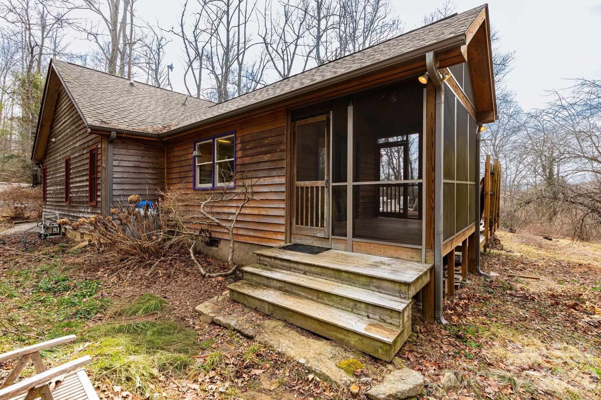 341 Sugar Hollow Road Fairview, NC 28730 - Photo 4 of 24 a backyard of a house with table and chairs