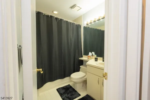 a bathroom with a sink a toilet and shower curtain