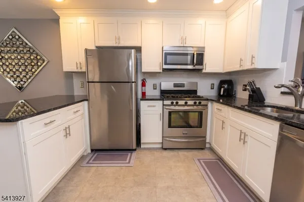a kitchen with white cabinets and white appliances