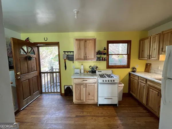a view of a kitchen with wooden floor and electronic appliances