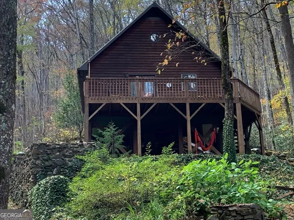 a view of house with balcony and trees